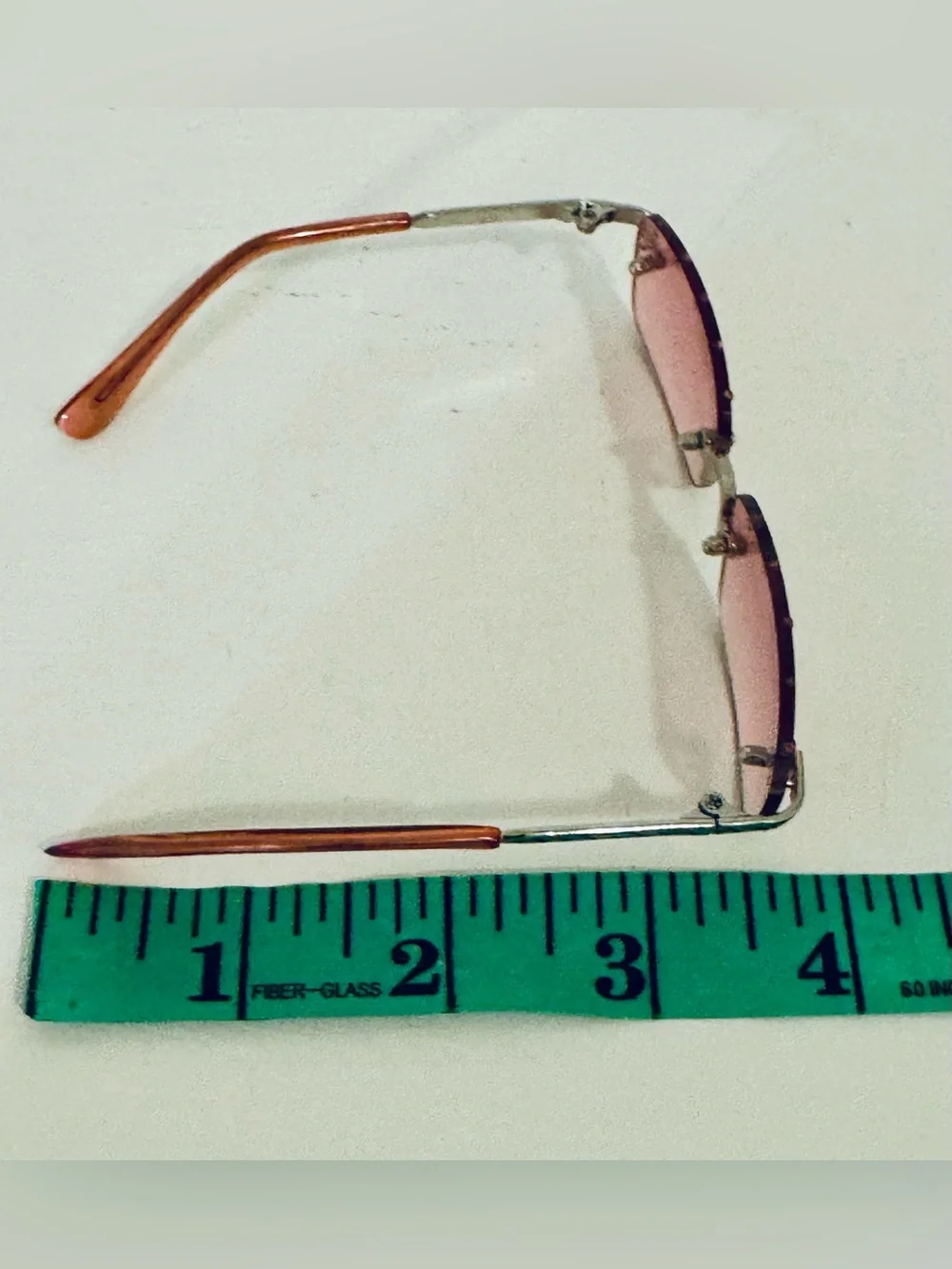 Stylish pink rimless sunglasses adorned with decorative rhinestones. These glass